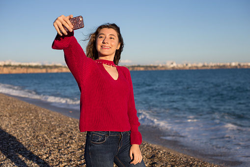 Young woman taking a selfie at beach