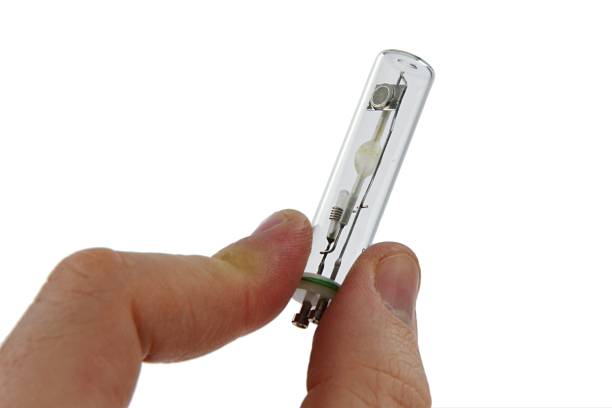istock Small metal halide light bulb with GU10 10 mm mount held in right index finger and thumb 1131565616