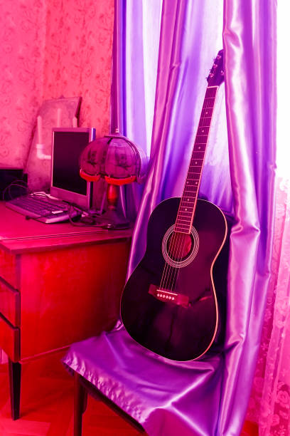 istock guitar that stands on a chair next to the table 1131565798