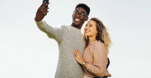 istock Interracial couple on holiday taking selfie 1131566014