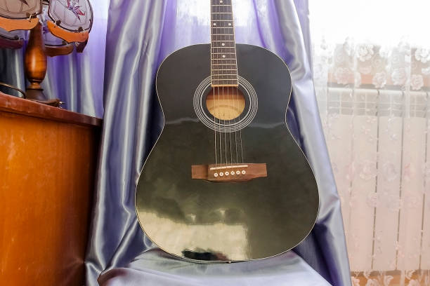 istock guitar that stands on a chair next to the table 1131566101