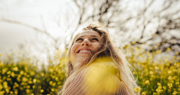 istock Smiling young woman sitting in meadow 1131566107