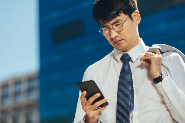 istock Businessman reading text message on his mobile phone outdoors 1131566385