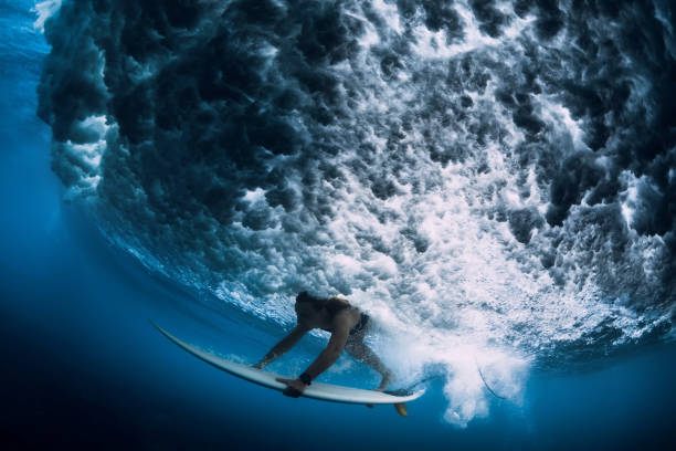 istock Attractive surfer woman dive underwater with under big wave. 1131567218