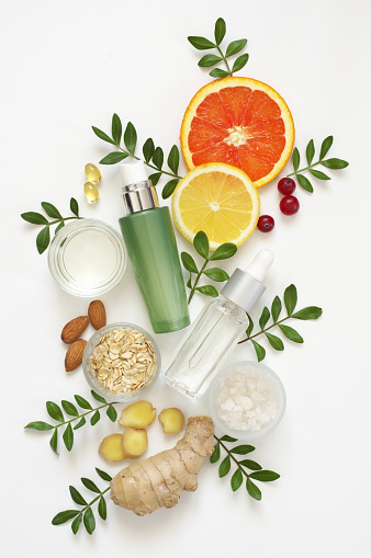 Composition of natural organic cosmetics, ingredients and leaves on white background. Top view point, flat lay.