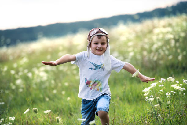 istock A small boy with pilot hat running in nature on a summer day. 1131579192