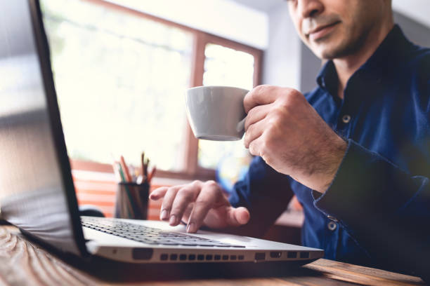 istock Man Working on Computer and Having His Coffee in Office Room 1131579549