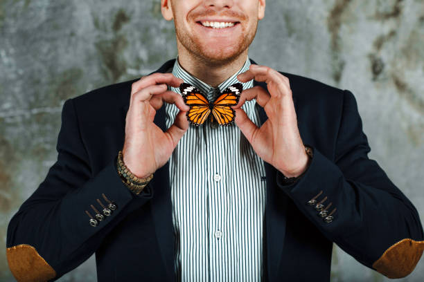 istock Smiling male in suit with bow tie like butterfly. 1131579795