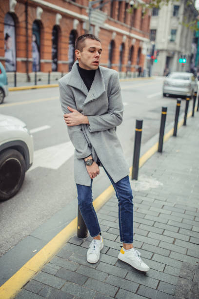 istock Young man in gray coat standing on the street 1131584016