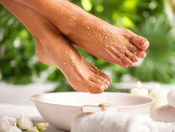 Photo of Foot spa on a tropical green leaves background