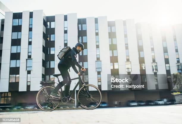 Male Courier With Bicycle Delivering Packages In City Copy Space Stock Photo - Download Image Now