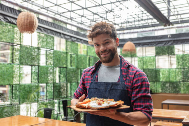 istock Handsome latin american waiter holding an order with schnitzel smiling at camera 1131587065