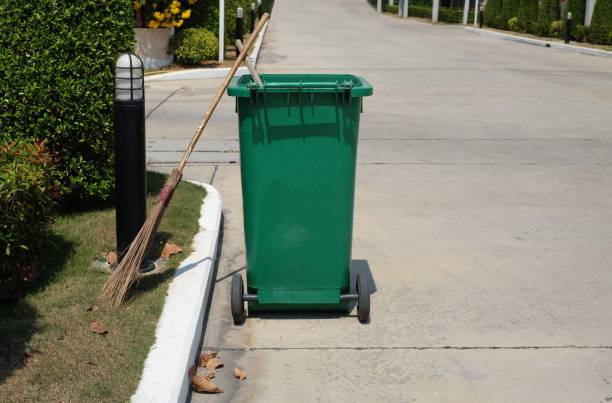 istock Broom and green bin placed next to the roadside path after cleaning 1131589982
