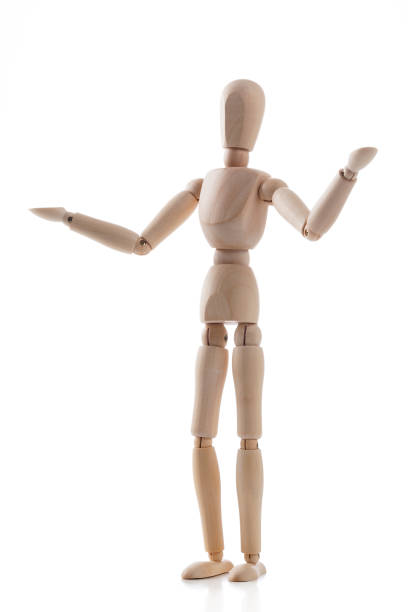 Wooden mannequin standing on white background like giving a speech and showing something. Predominant colors are brown and white. High key DSRL studio photo taken with Canon EOS 5D Mk II and Canon EF 100mm f/2.8L Macro IS USM.
