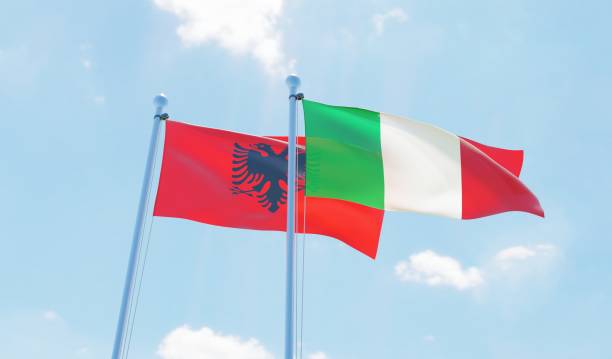 istock Italy and Albania, two flags waving against blue sky 1131594630