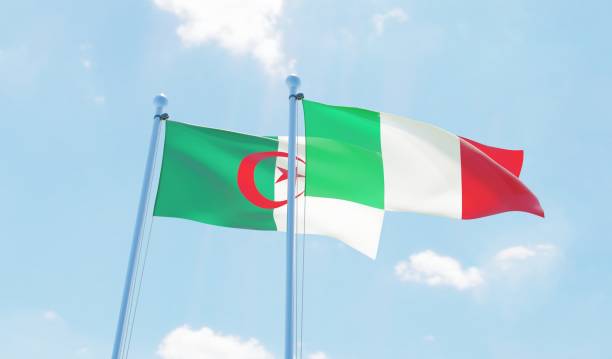 istock Italy and Algeria, two flags waving against blue sky 1131594637