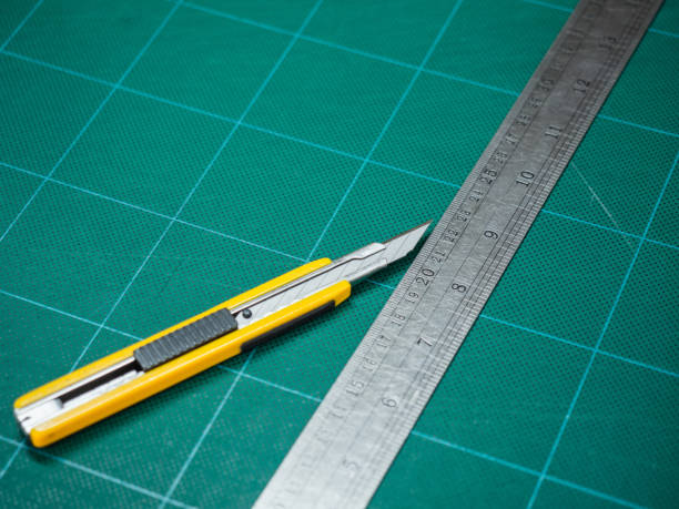 Cutter And Iron Ruler Isolated On A Cutting Mat Stock Photo