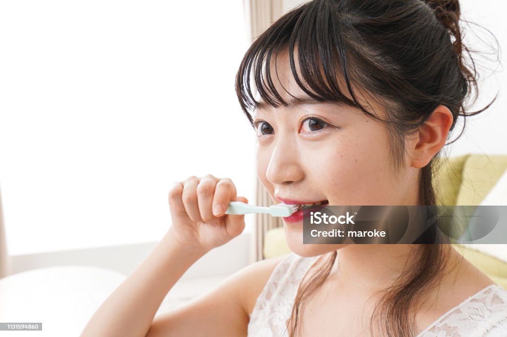 Young woman brushing a tooth Adult Stock Photo