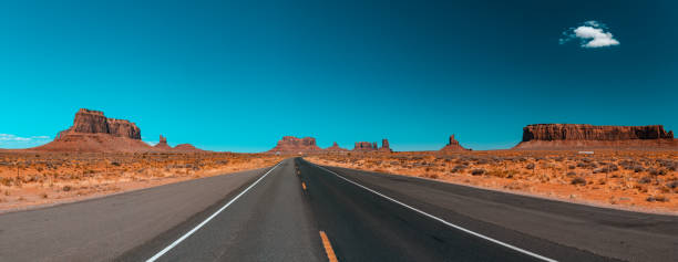 モニュメントバレーを通る無限の無限の道 - plant sunset utah canyon ストックフォトと画像