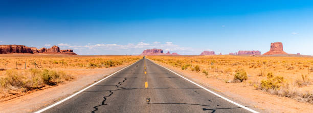 Endless infinite road that goes through the Monument Valley Endless infinite road that goes through the Monument Valley National park with amazing rock formations. number 66 stock pictures, royalty-free photos & images
