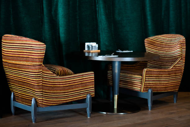 istock Closeup of new modern blue retro chairs by windows with natural light and empty table 1131596680
