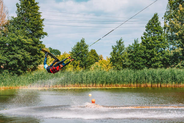 giovane wakeboard su un lago - wakeboarding nautical vessel wake jumping foto e immagini stock