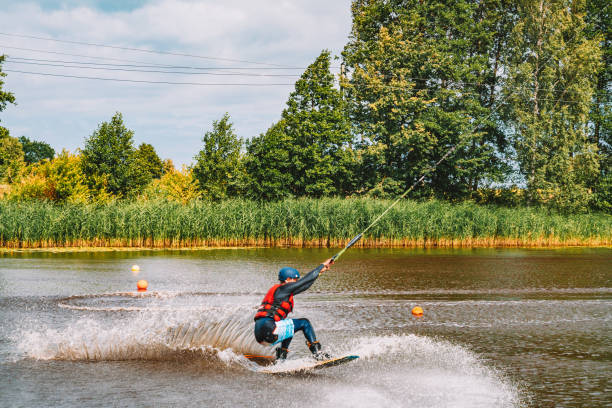 giovane wakeboard su un lago - wakeboarding nautical vessel wake jumping foto e immagini stock