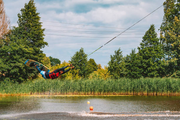 giovane wakeboard su un lago - wakeboarding nautical vessel wake jumping foto e immagini stock