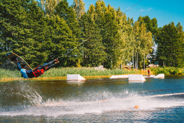 giovane wakeboard su un lago - wakeboarding nautical vessel wake jumping foto e immagini stock