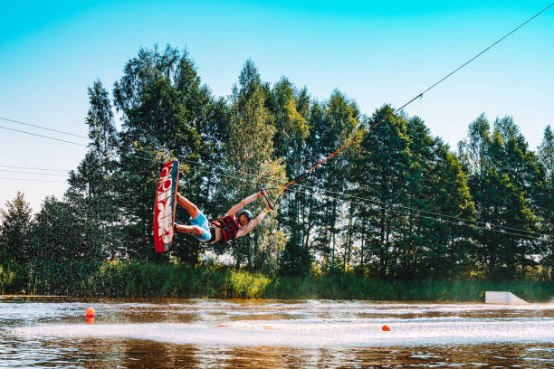 giovane wakeboard su un lago - wakeboarding nautical vessel wake jumping foto e immagini stock