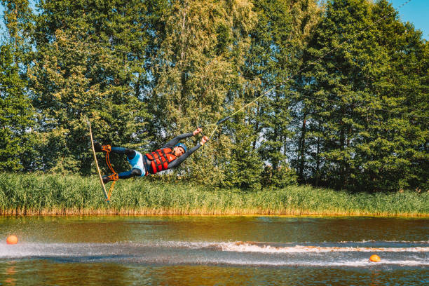 giovane wakeboard su un lago - wakeboarding nautical vessel wake jumping foto e immagini stock