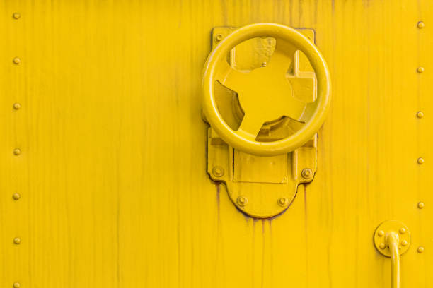 weathered yellow painted metal surface background with valve wheel