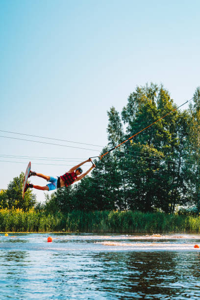 giovane wakeboard su un lago - wakeboarding nautical vessel wake jumping foto e immagini stock