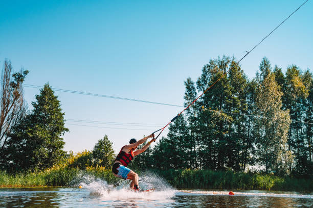 giovane wakeboard su un lago - wakeboarding nautical vessel wake jumping foto e immagini stock