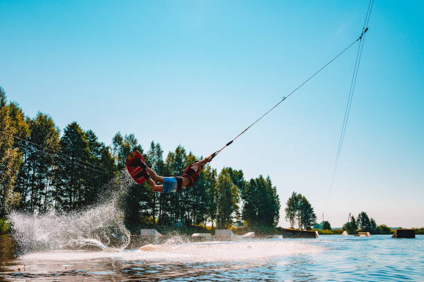 giovane wakeboard su un lago - wakeboarding nautical vessel wake jumping foto e immagini stock
