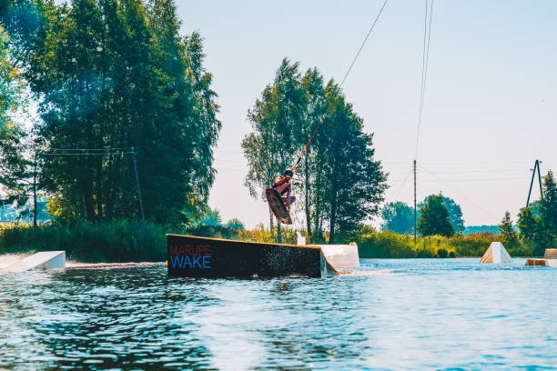 giovane wakeboard su un lago - wakeboarding nautical vessel wake jumping foto e immagini stock