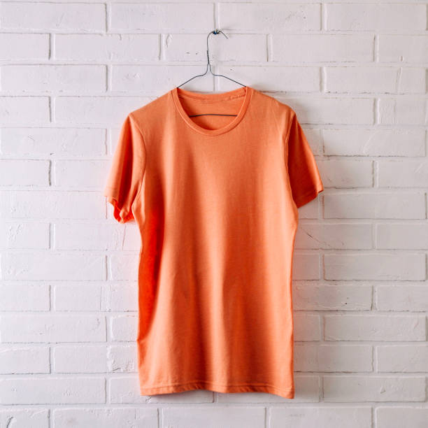 istock Orange t-shirt on a pale background. Template for text or design 1131602673