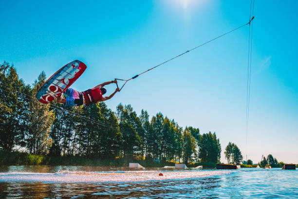 giovane wakeboard su un lago - wakeboarding nautical vessel wake jumping foto e immagini stock