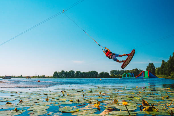 giovane wakeboard su un lago - wakeboarding nautical vessel wake jumping foto e immagini stock