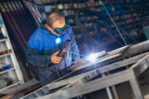 Arc welder with welding mask and sparks Arc welder with welding mask and sparks welder engineering construction bright stock pictures, royalty-free photos & images