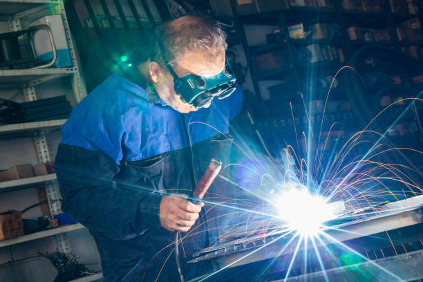 Arc welder with welding mask and sparks Arc welder with welding mask and sparks welder engineering construction bright stock pictures, royalty-free photos & images