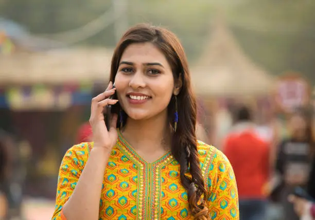 Indian woman talking on mobile phone at street market