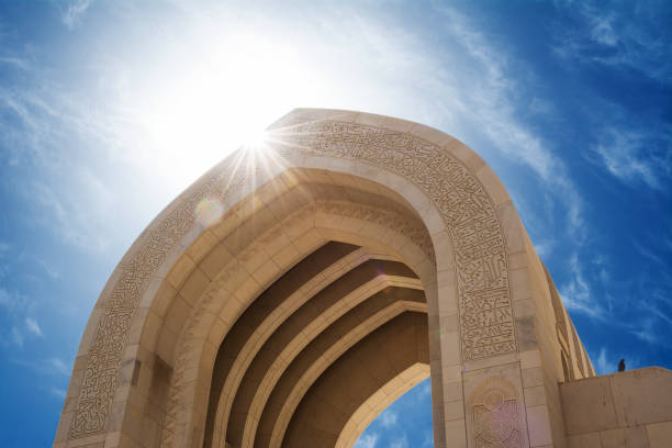 detalhe de um arco da mesquita grande de muscat com o sol no retroiluminação (oman) - oman - fotografias e filmes do acervo