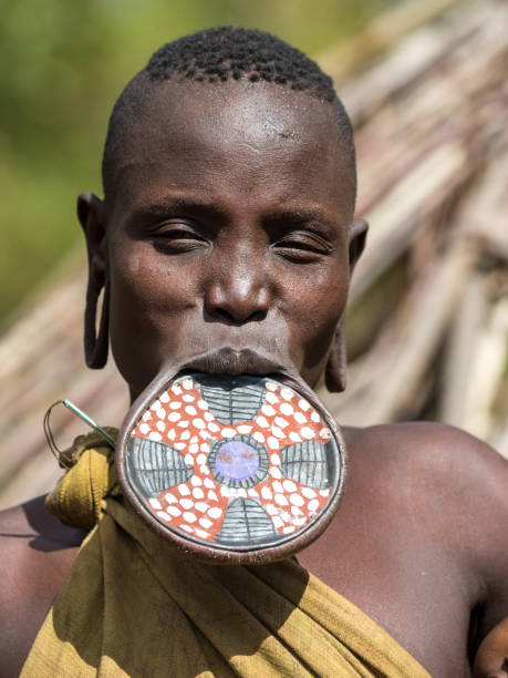 A woman of the Mursi tribe wearing a traditional lip plate in a village in the Omo Valley.