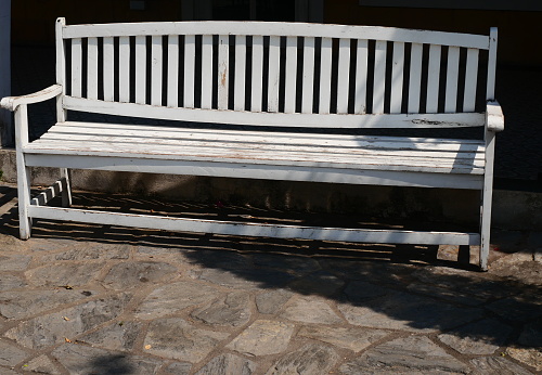 A rustic wooden bench and a wooden vase in the sun in Campos do Jordão
