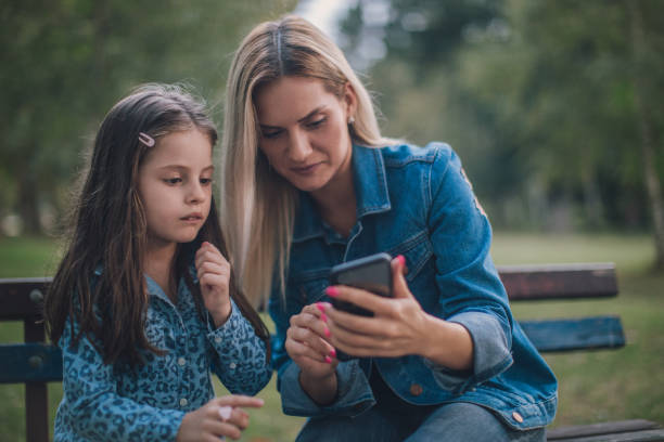 istock Mother and daughther making selfie in park 1131615196