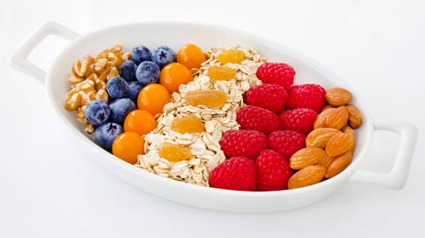 desayuno en copos de roble con frutas y nueces - oatmeal porridge oat raisin fotografías e imágenes de stock