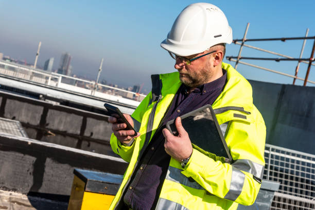 istock Architect in protective workwear on the building site is working on his phone 1131617575