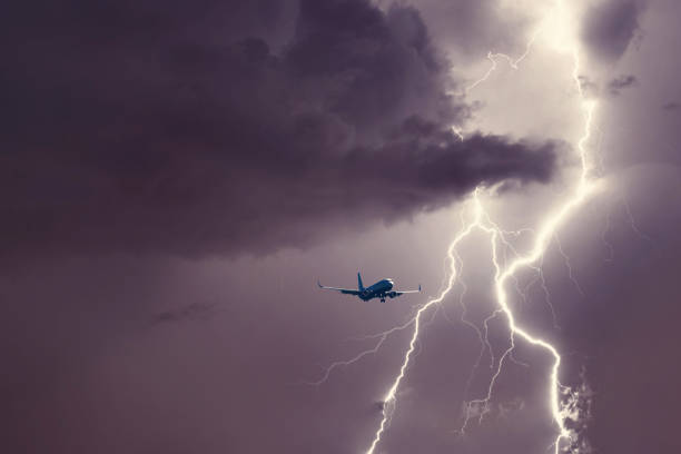 Passenger airplane landing in the stormy weather on the backdrop lightning stock photo