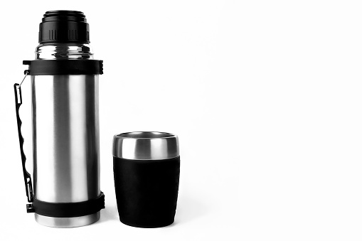 Thermos of hot and cold drinks. On white background and with glass.